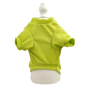 Detail showing bright green pet t-shirt texture and ribbed hem on a small white dog