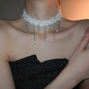 Close-up of white plush choker with crystal tassel chain on a model's neck