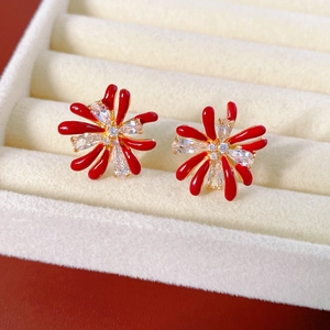 Macro detail of red flower earrings with 18k gold plating and sparkling zircon stones