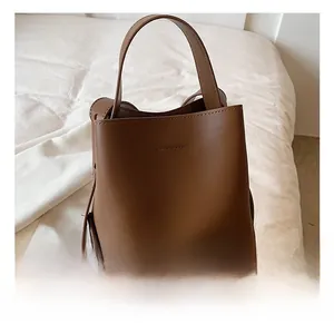 Detailed macro view of the brown synthetic leather texture on a bucket handbag