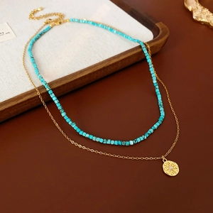 Détail du collier double rang avec pendentif étoile dorée et perles turquoise