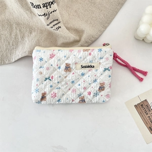 Detailed view of quilted cotton pouch featuring cute bear print and floral snowflake patterns