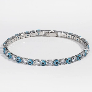Macro detail of silver evil eye tennis bracelet with blue beads and cubic zirconia