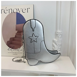 Close-up of silver boot-shaped handbag with star detail and metal chain strap