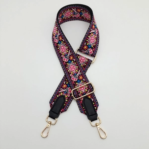 Detail of adjustable thick canvas strap with ethnic embroidery and gold metal lobster clips