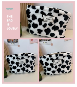 Detail view of plush cow print pouch featuring a TIME TO PARTY label on soft faux fur