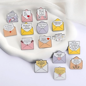 Set di spille smaltate a forma di lettere d'amore con frasi motivazionali su vassoio