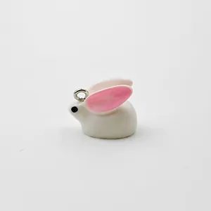 Macro view of white resin rabbit charm with pink ears and dimensions 20mm by 15mm