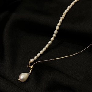 Baroque freshwater pearl necklace with adjustable gold chain on black textured fabric