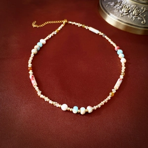 Detail of colorful beaded necklace with sky blue stones and gold lobster clasp