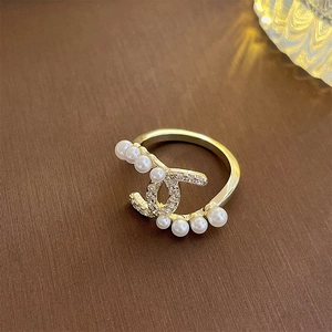 Detailed view of gold-plated double-C ring featuring sparkling zircons and white pearls