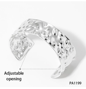 Detail of wide silver irregular hammered texture cuff with adjustable opening