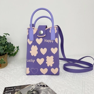 Detail of purple knit phone bag featuring cartoon bear patterns and Happy Lucky lettering