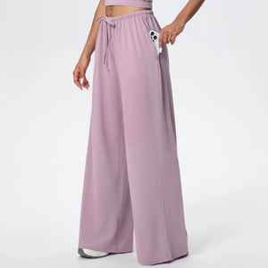 Detail of loose purple yoga pants featuring drawstring waist and large side phone pocket