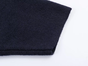 Close-up of deep blue fleece fabric showing thick texture and sleeve stitching detail