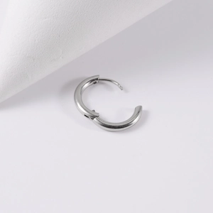Close-up of polished silver stainless steel hoop earring with a hinge closure mechanism