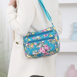 Floral print crossbody shoulder bag for women with multi-zipper compartments on white suit