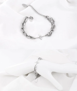 Detail eines silbernen Sternanhänger-Armbands mit doppelter Gliederkette und Kristallen