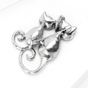 Macro shot of silver metal cat brooch back showing needle clasp and heart shaped tails