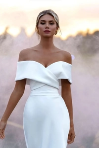 Detail of off-shoulder satin bridal gown featuring elegant crisscross pleated neckline design