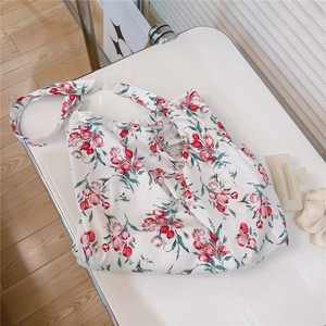 Detail view of cotton floral tote bag with red tulip patterns and hair accessories