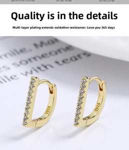 Macro shot of gold-plated 925 silver D-shape earrings with inlaid white zircon stones