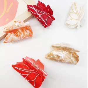 Leaf-shaped acetate hair claws in assorted marble colors and plain finishes