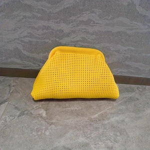Detalle macro del bolso nube de punto amarillo brillante con textura suave tejida