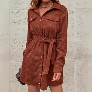 Detail of caramel corduroy shirt dress featuring waist tie and front button flap pockets