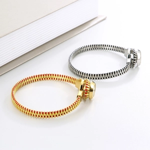 Close-up of zipper-style titanium steel bracelets in gold-red and silver-black finishes