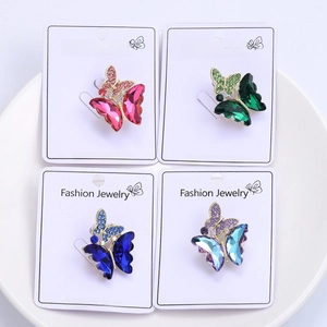 Detailed set of four butterfly crystal brooches in various colors on white display cards