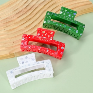 Close-up of three Christmas acrylic hair claws in green, red, and white with festive prints