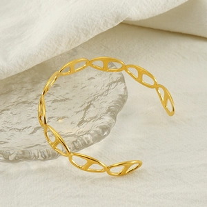 Détail macro d'un bracelet doré à maillons de nez de porc sur verre ondulé