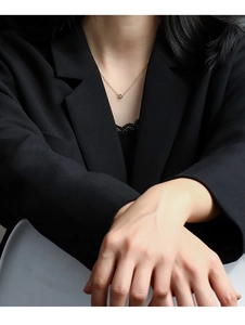Elegant gold choker necklace with round cubic zirconia pendant on model in black blazer