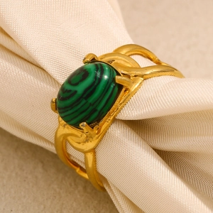 Detailed close-up of 18K gold plated ring featuring oval green malachite on silk fabric
