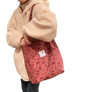 Corduroy tote bag with red floral pattern and white text patch for daily shopping
