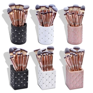 Macro shot of colorful makeup brush sets in quilted storage holders with rose gold handles