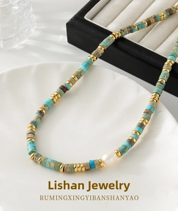 Close-up of bohemian Jasper beaded necklace with turquoise stones and baroque pearl