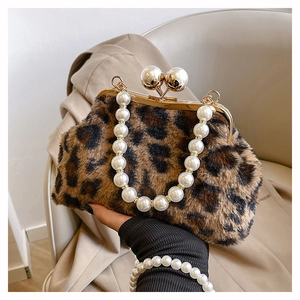 Detail of leopard print faux fur handbag with elegant pearl handle and gold clasp