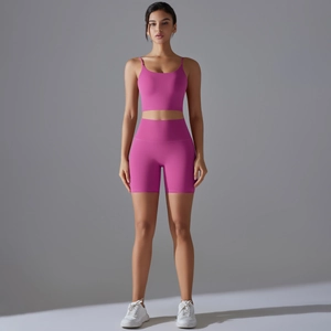 Dettaglio del set da yoga magenta con pantaloncini a vita alta e top corto sportivo