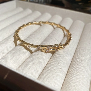 Detailed macro view of 18K gold bamboo-joint bangle featuring micro-set zircon accents