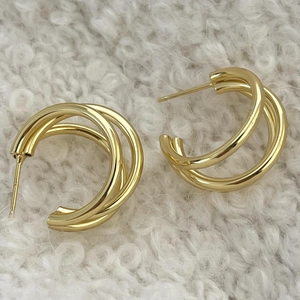 Detailed close-up of triple-layered interlocking gold rings of a 925 silver stud earring