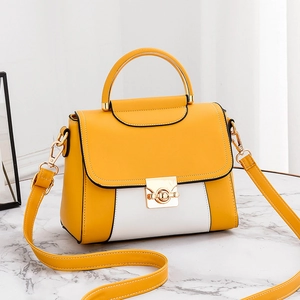 Fashionable yellow and white crossbody handbag with gold hardware on marble background