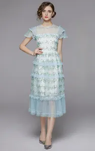 Détail de la robe à volants bleu clair avec broderies florales et manches à froufrous