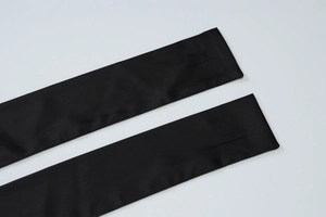 Detailed close-up of smooth black fabric straps with a silky finish on a white background