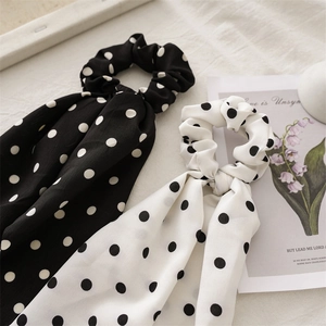 Close-up of black and white polka dot bow hair scrunchies with long fabric ribbons