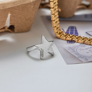 Macro shot of silver pentagram ring with BLESSING engraving on polished stainless steel