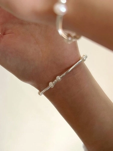 Detail of S925 sterling silver bracelet with freshwater pearls on woman wrist