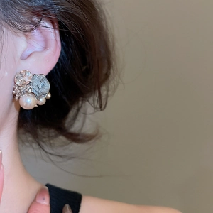 Detailed close-up of vintage flower pearl earrings with crystals on a female model