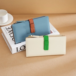 Chic color-block long wallets in pebble grain leather with snap closure on a desk